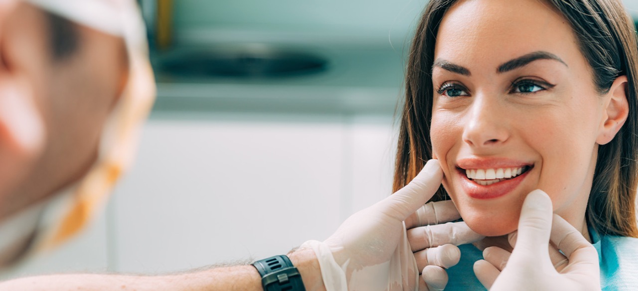 Odontólogo examinando el tratamiento de estética dental en la sonrisa su paciente