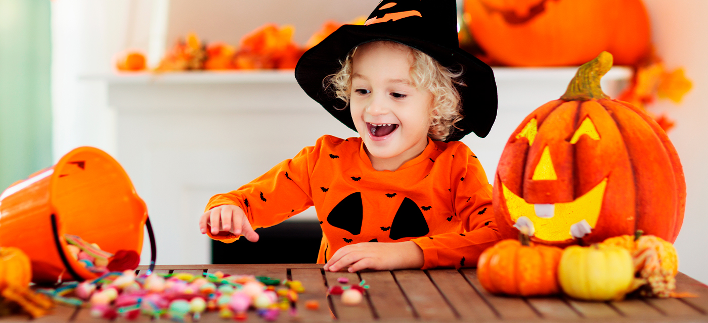 Niño disfrazado de calabaza contando los dulces para halloween que recogió 