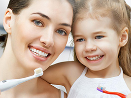 Mamá e hija con cepillo de dientes