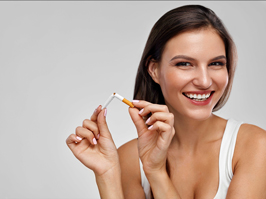 Mujer con implantes dentales rompiendo un tabaco