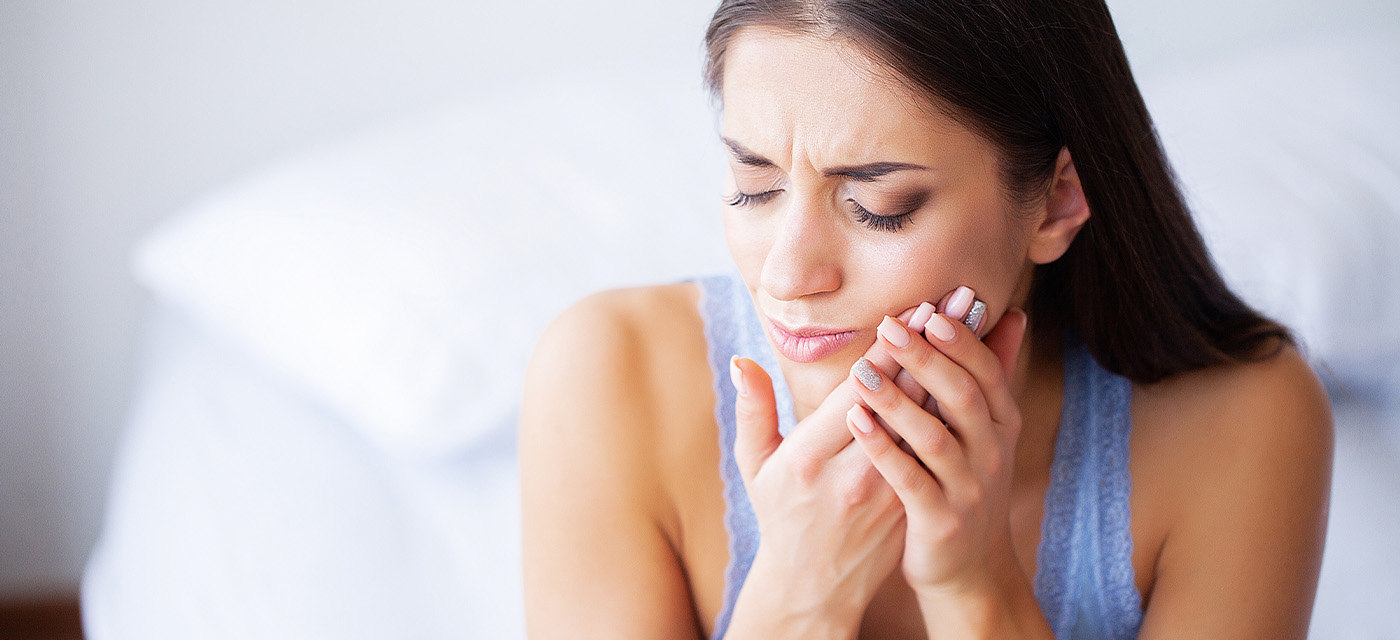 mujer con dolor de diente por infección dental