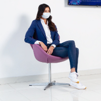 Mujer con tapabocas sentada en clínica
