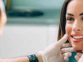 Odontólogo examinando el tratamiento de estética dental en la sonrisa su paciente