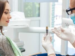 Dentista explicando a paciente proceso de implante dental