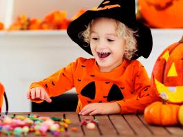 Niño disfrazado de calabaza contando los dulces para halloween que recogió 