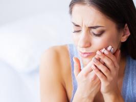 mujer con dolor de diente por infección dental