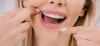 Mujer limpiando sus dientes con Seda Dental